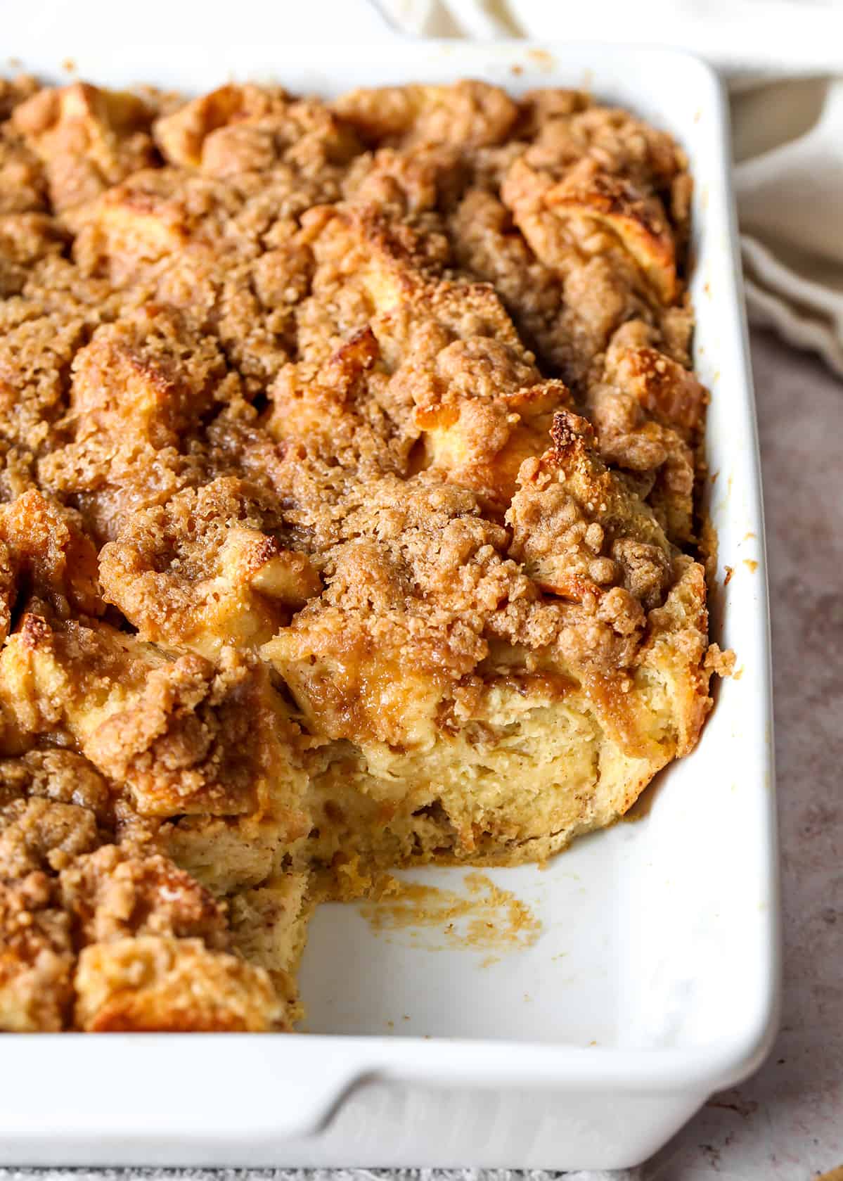 front view of overnight French Toast Casserole in a baking dish with a piece removed