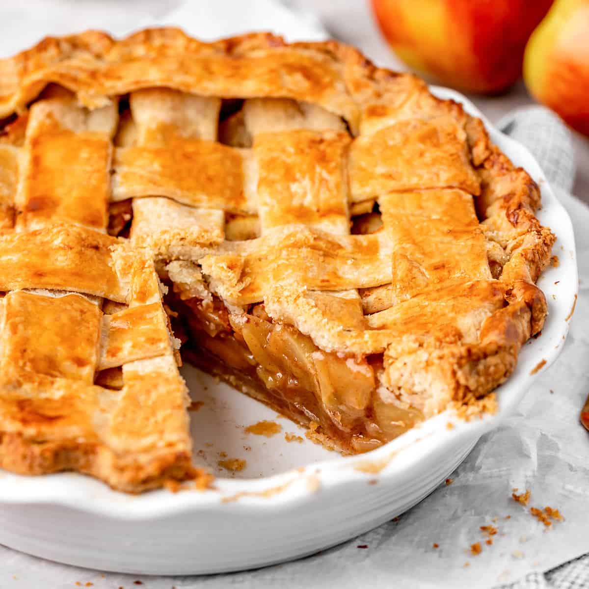 a baked apple pie with one piece cut out of it in the pie dish