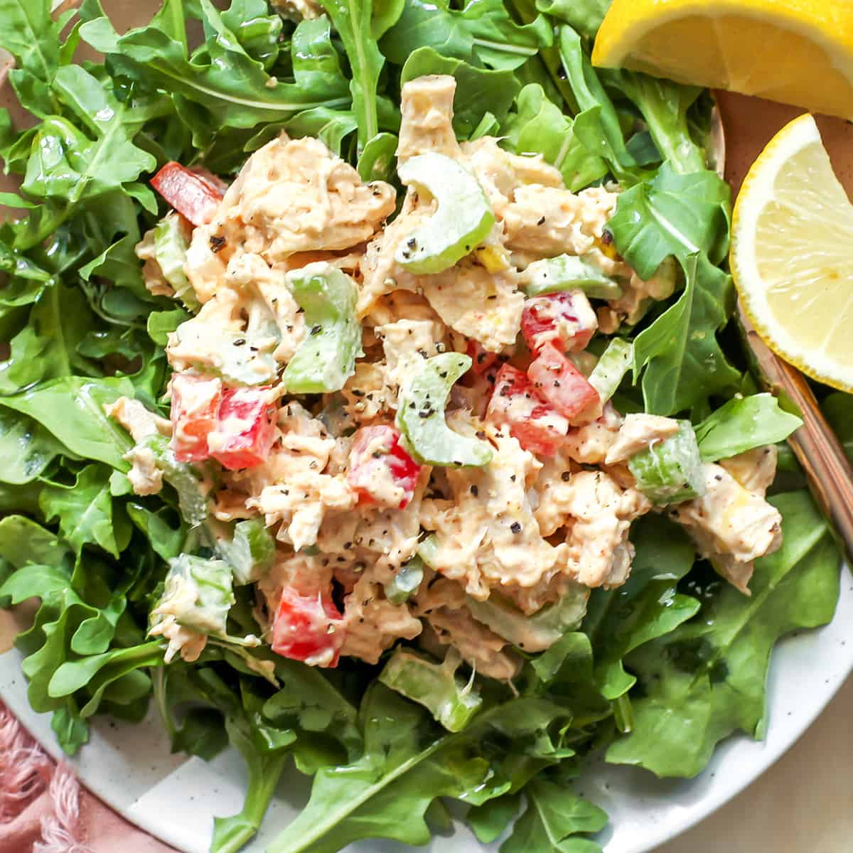 classic chicken salad served on top of arugula on a plate