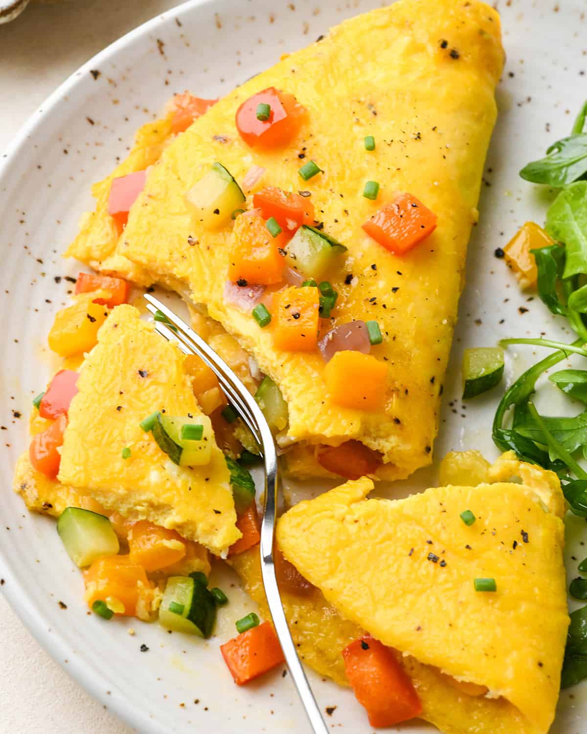 a fork taking a bite of a vegetable omelette