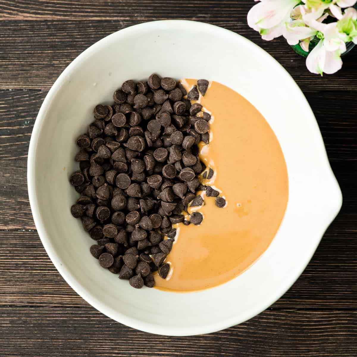 Overhead photo showing how to make puppy chow - combining peanut butter and chocolate chips
