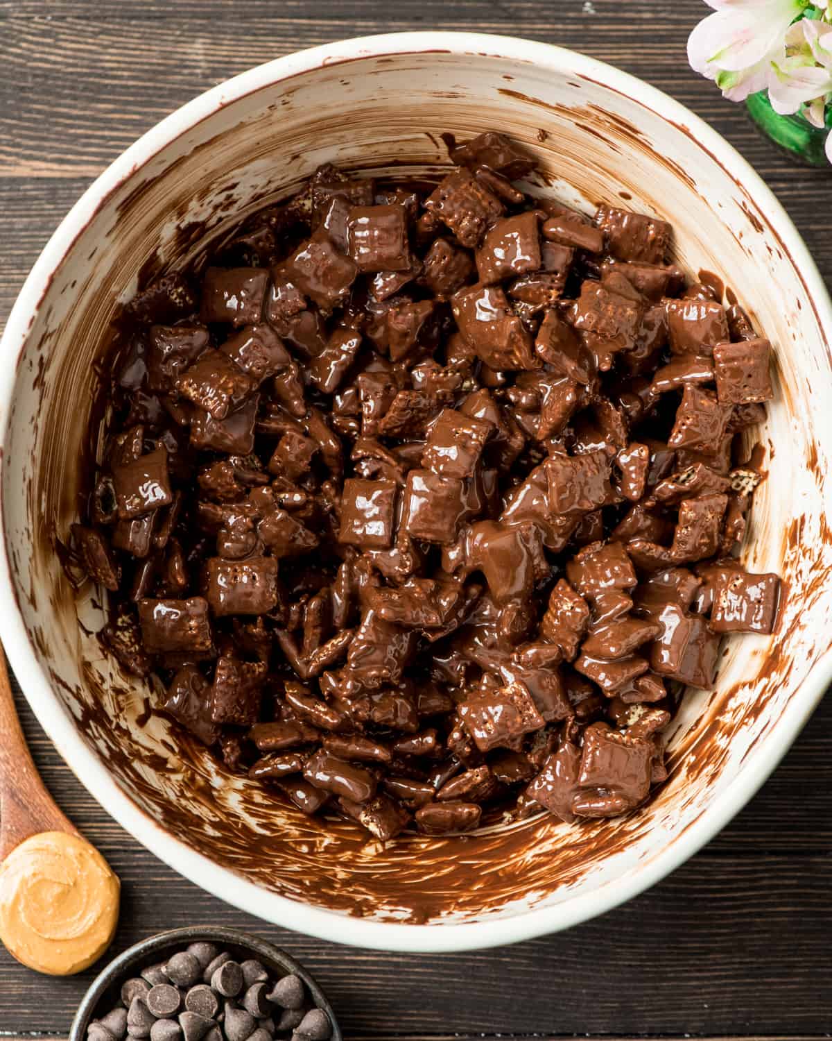 Overhead photo showing how to make muddy buddies (puppy chow) - peanut butter chocolate mixture stirred onto cereal