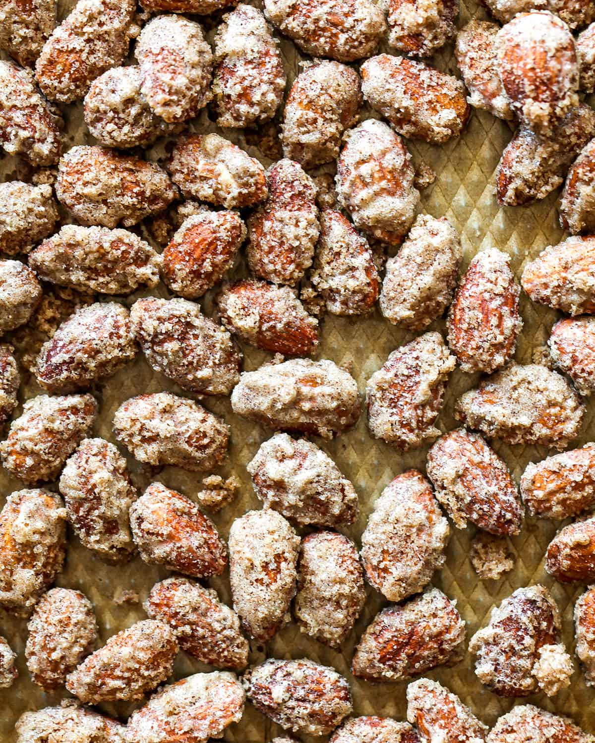overhead view of candied almonds after roasting on a baking sheet