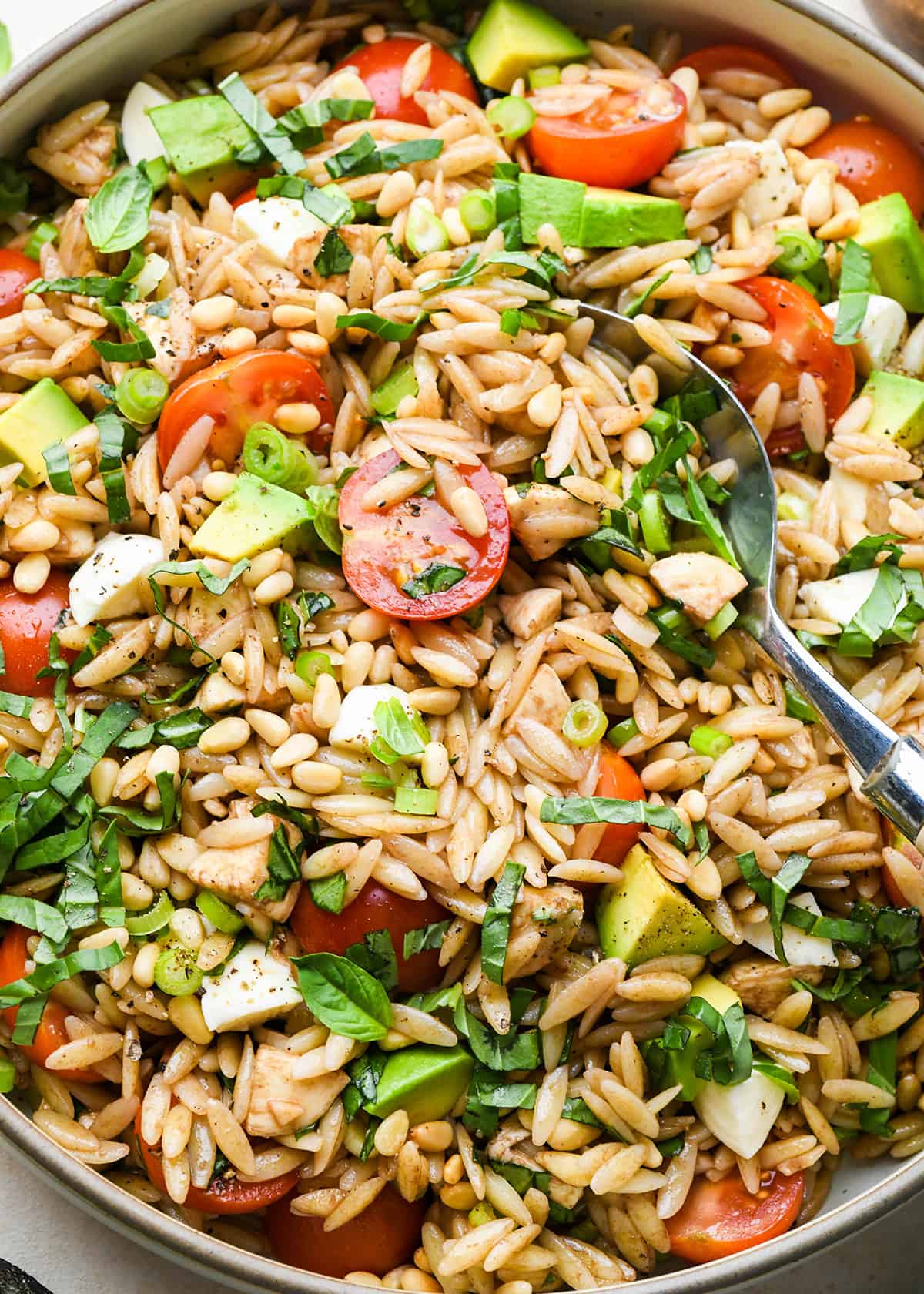 Caprese Orzo Salad in a serving bowl with a spoon