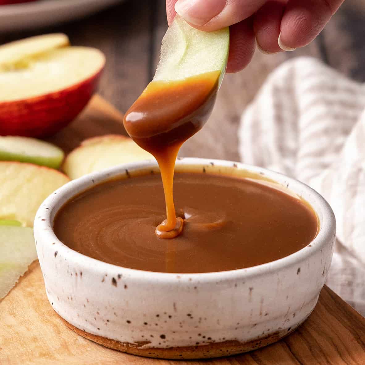 an apple after being dipped into a bowl of Caramel Apple Dip