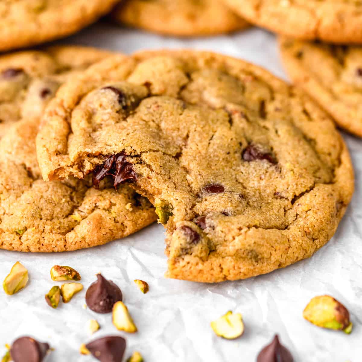 two Pistachio Cookies, one with a bite taken out of it