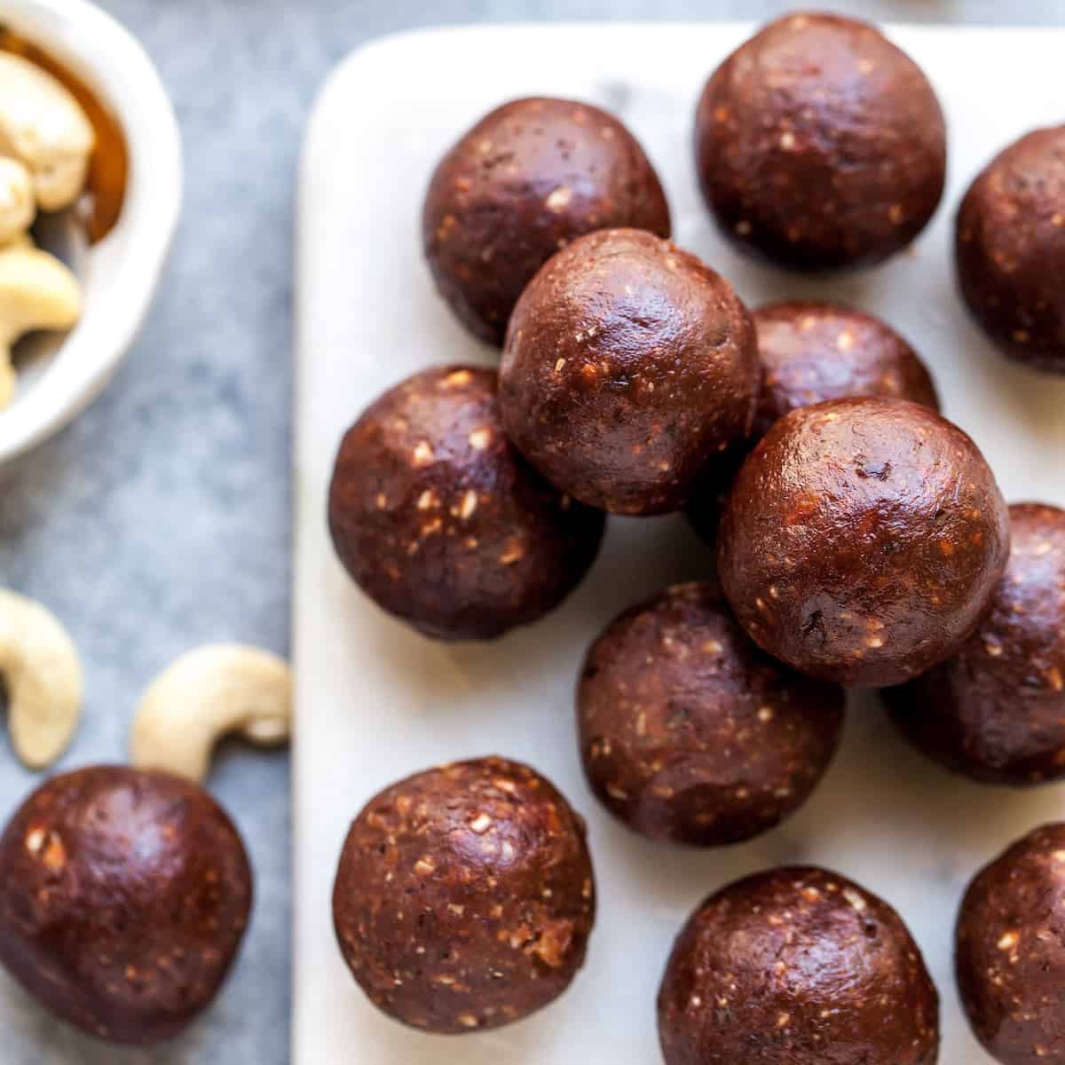 overhead view of 13 chocolate date energy balls on a serving board