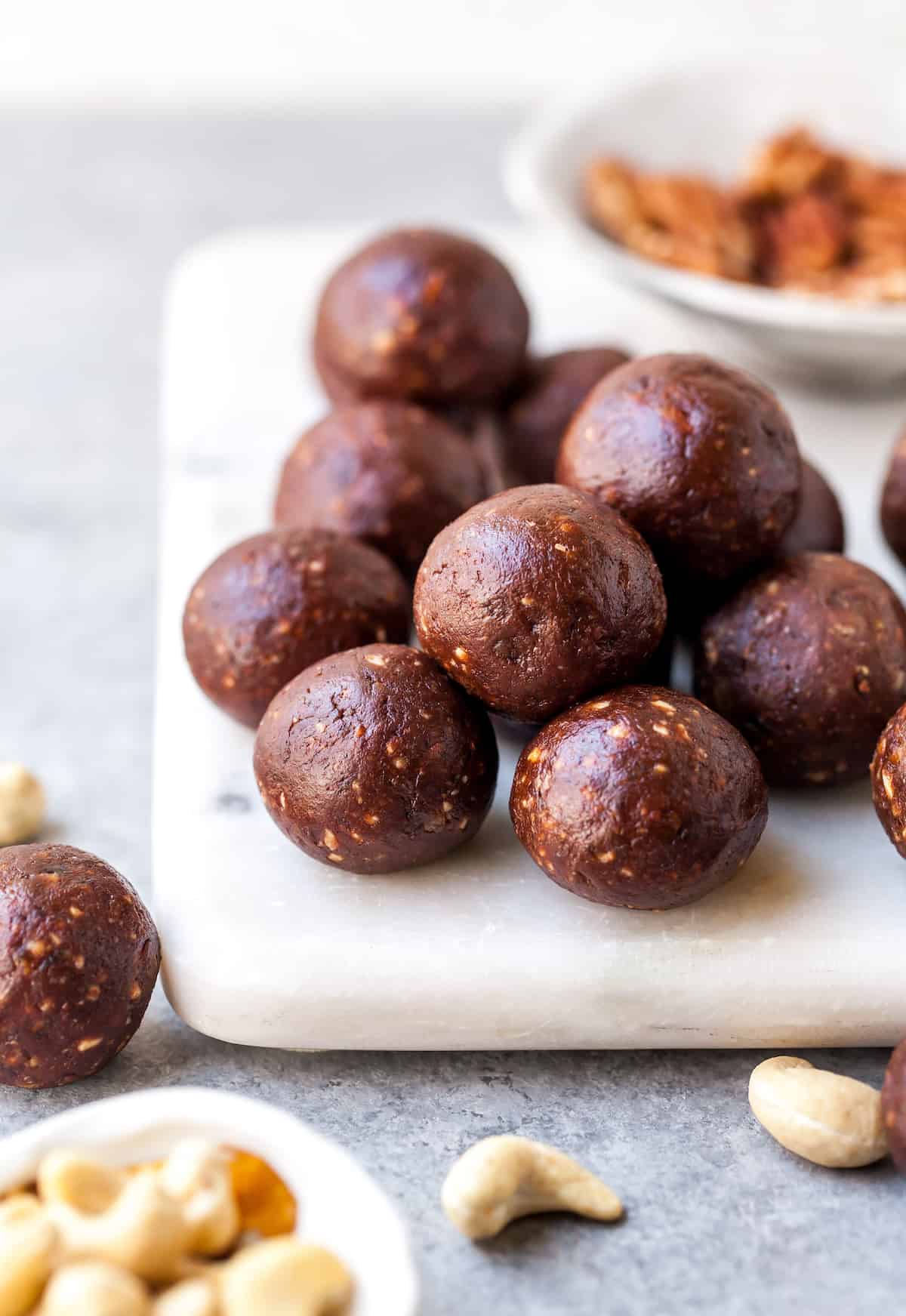 front view of chocolate date energy balls on a white serving board