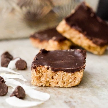 Finished No-Bake Coconut Almond Bars with chocolate chips next to them.