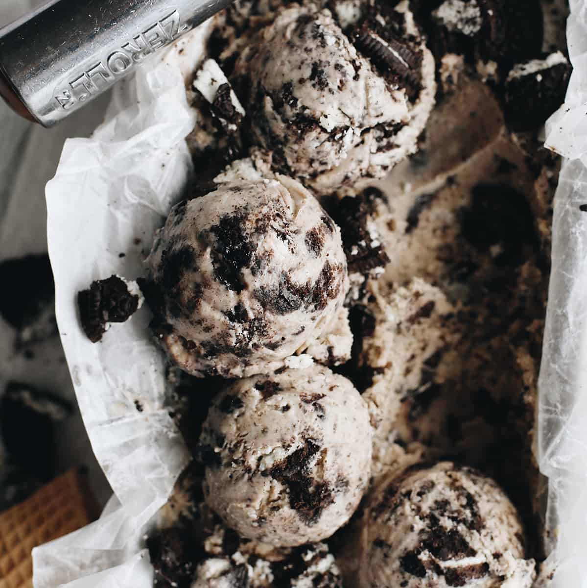 The best cookies and cream ice cream recipe! A creamy Oreo ice cream is loaded with crushed and chopped cookies for a big cookie flavor in every bite! overhead photo of scoops of Oreo ice cream