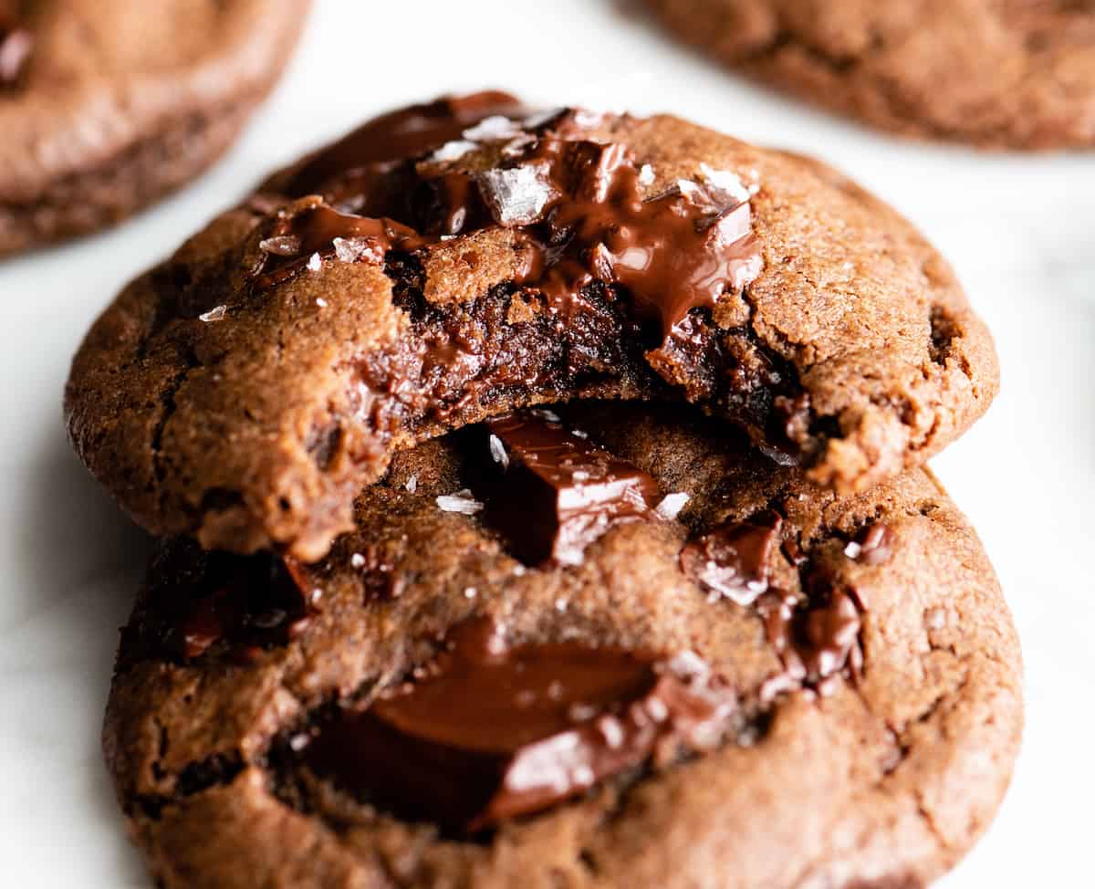 front view of two chocolate cookies, one with a bite taken out