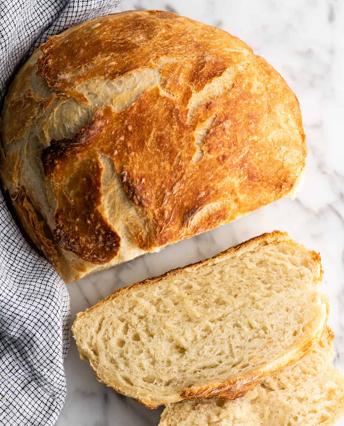 Overhead view of a loaf of dutch oven bread with two slices cut