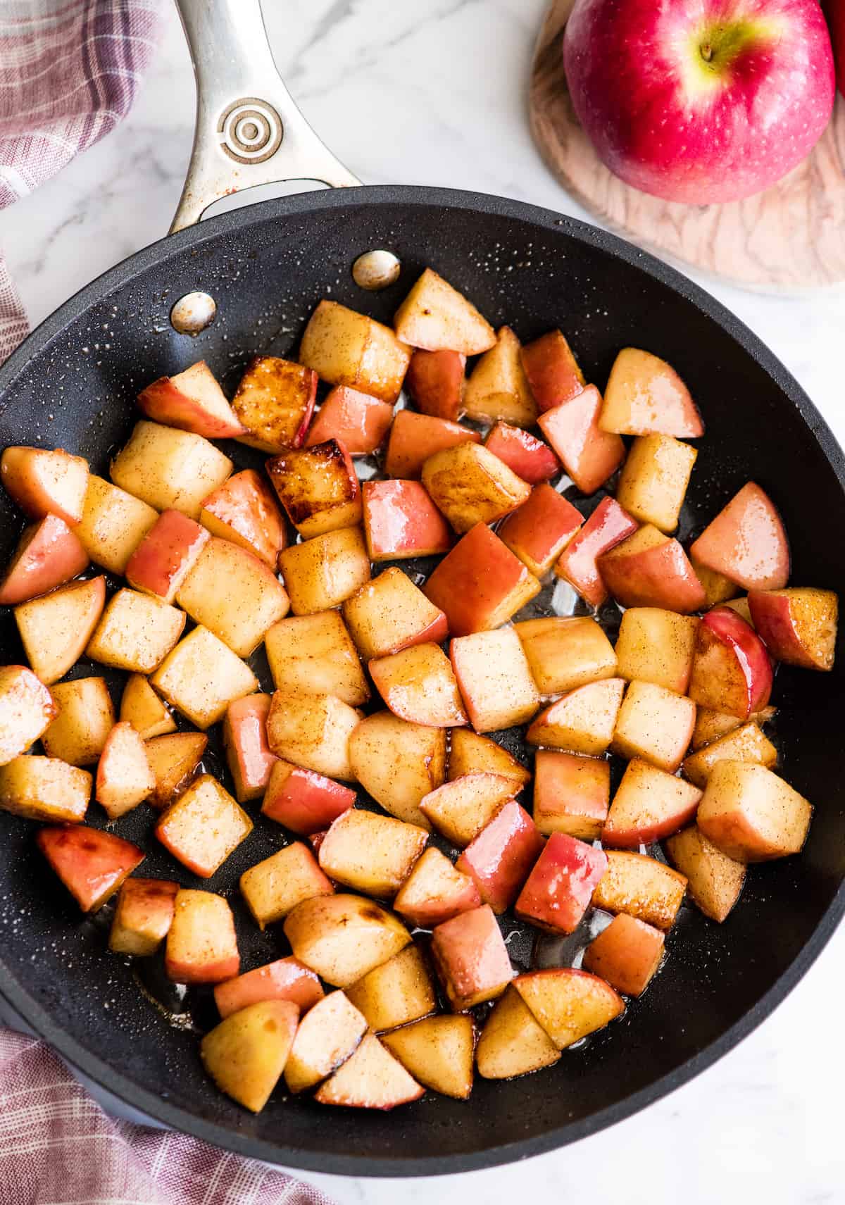 overhead view of sautéed cinnamon apples in a black nonstick fry pan