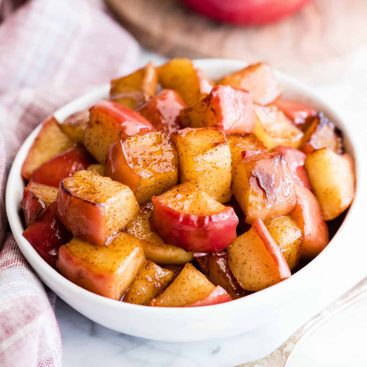 Overhead view of sautéed cinnamon apples in a white bowl