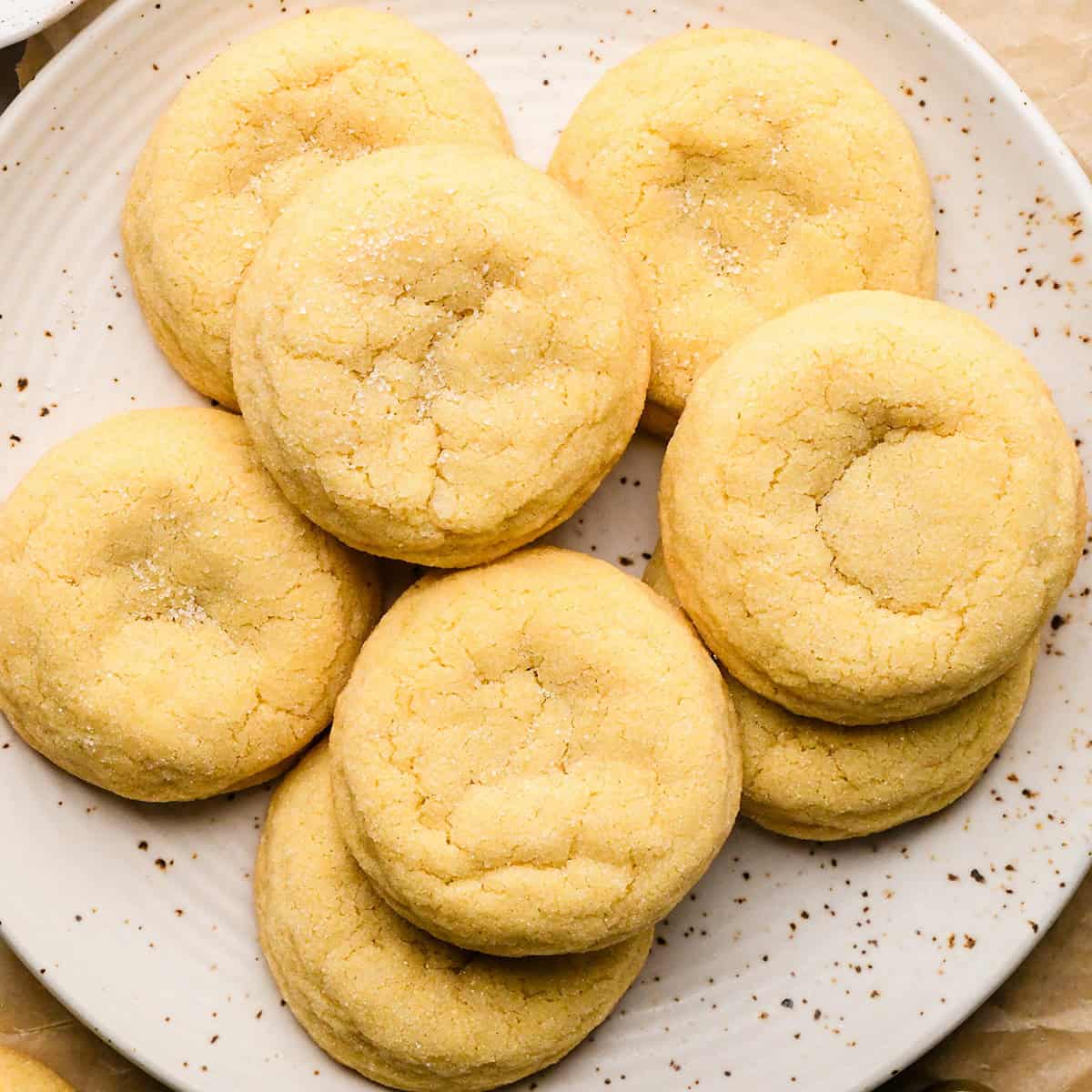 8 sugar cookies on a white pottery plate with granulated sugar sprinkled on top