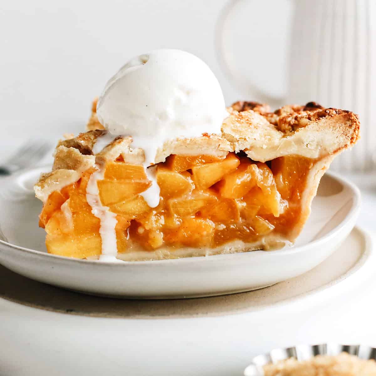 a slice of peach pie with vanilla ice cream on top