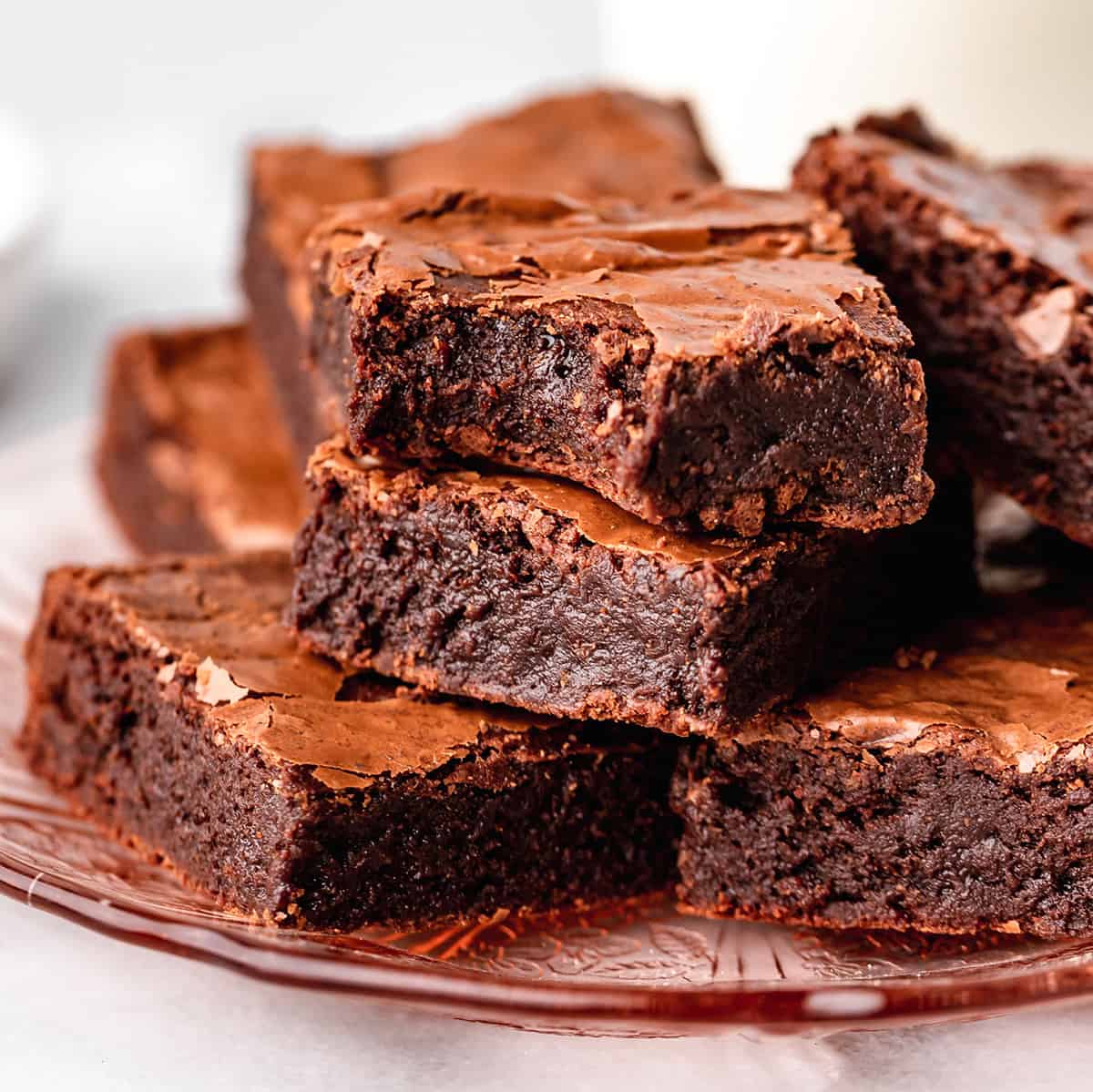 7 brownies stacked on a plate, one has a bite taken out of it