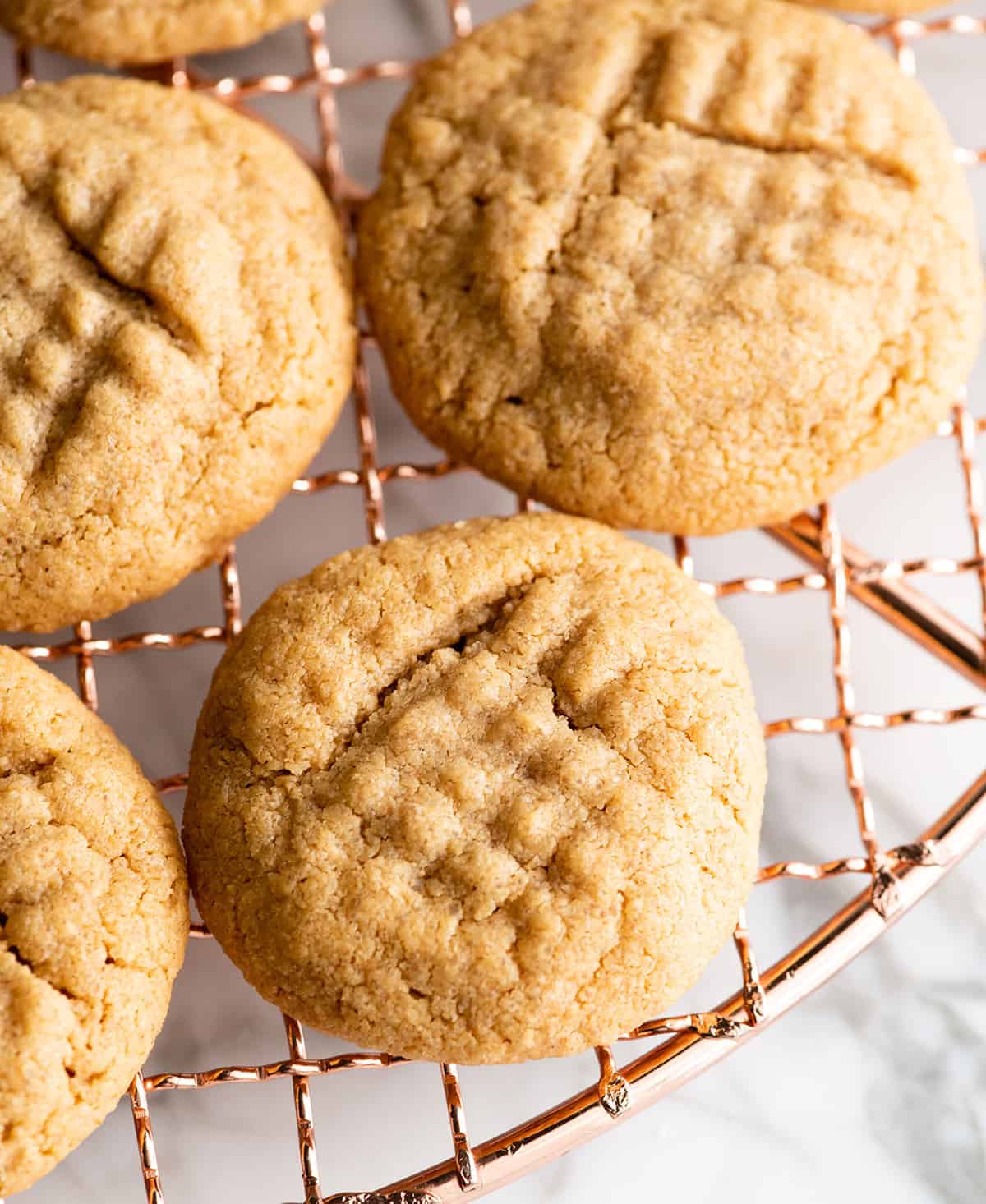 overhead view of 4 flourless peanut butter cookies on a cooling rack