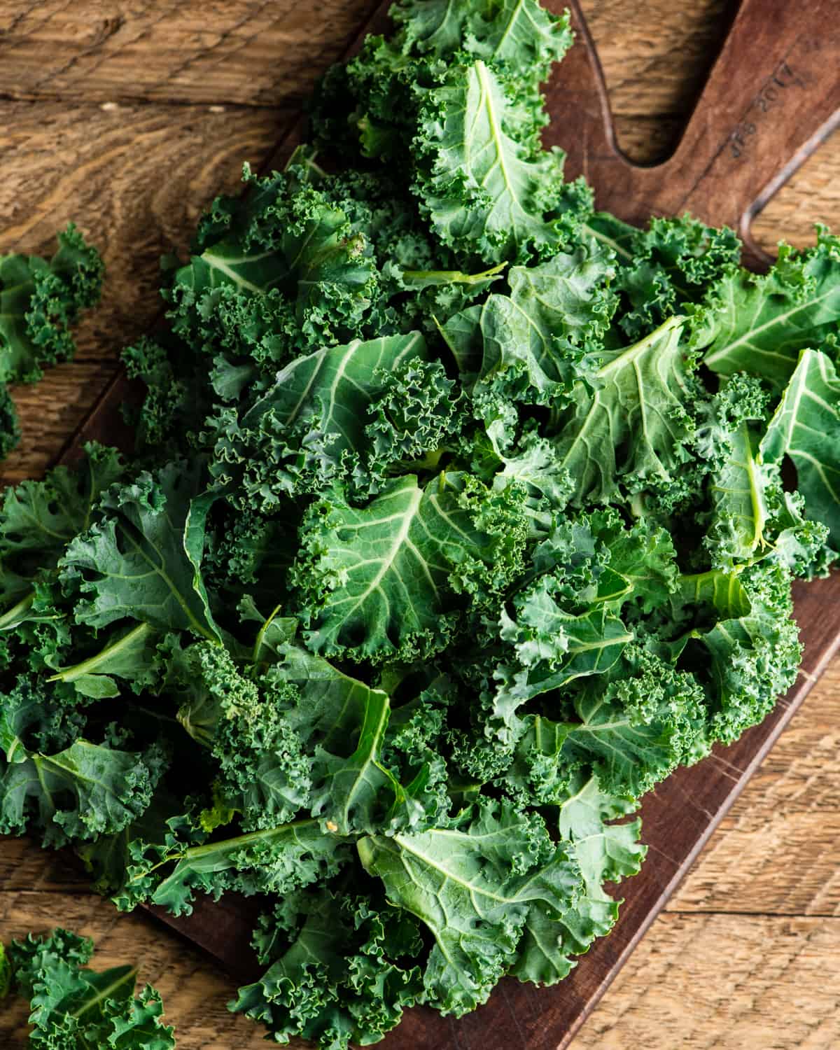 overhead view of Kale leaves on a cutting board ready to be made into baked kale chips