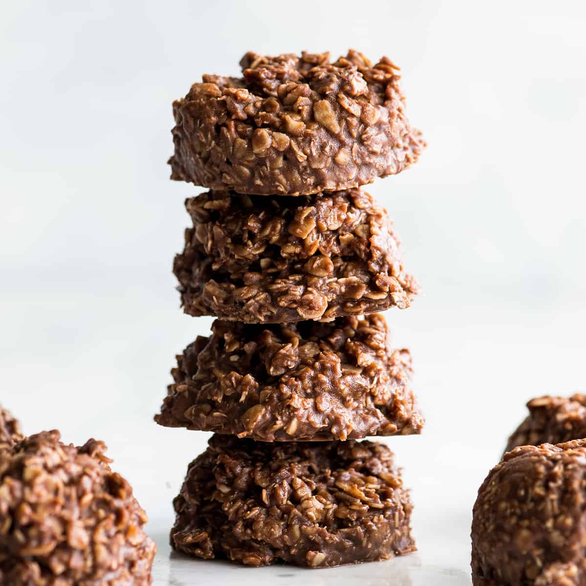 Healthy No-Bake Chocolate Peanut Butter Cookies! Made with only 8 good-for-you ingredients & ready in 30 minutes, they're a delicious treat you can feel great about eating! front view of a stack of 4 healthy no bake cookies