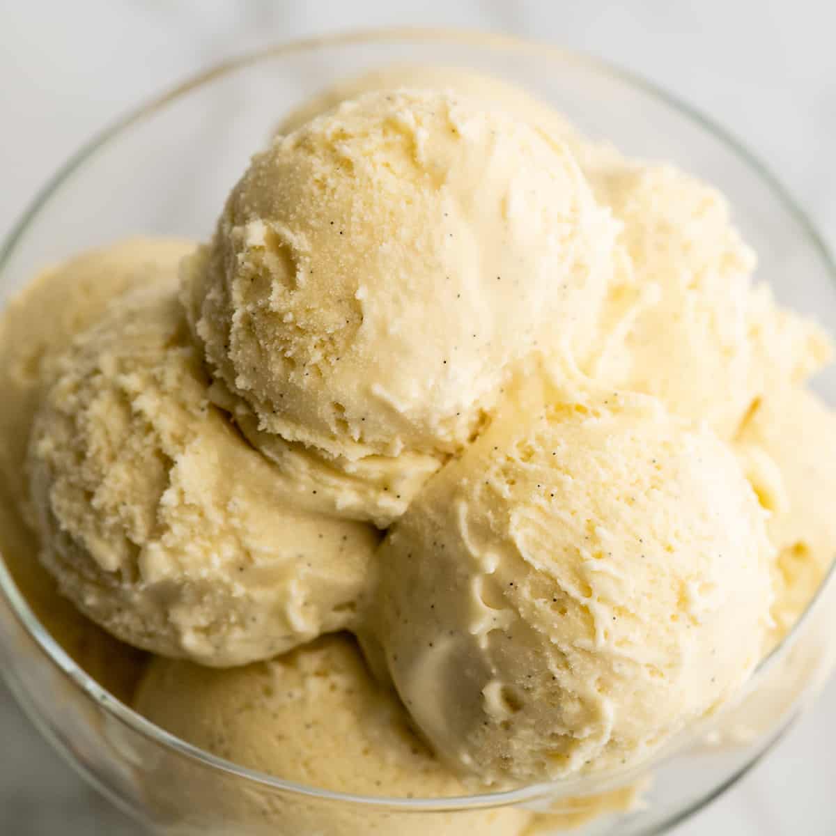 scoops of homemade vanilla ice cream in a glass dish