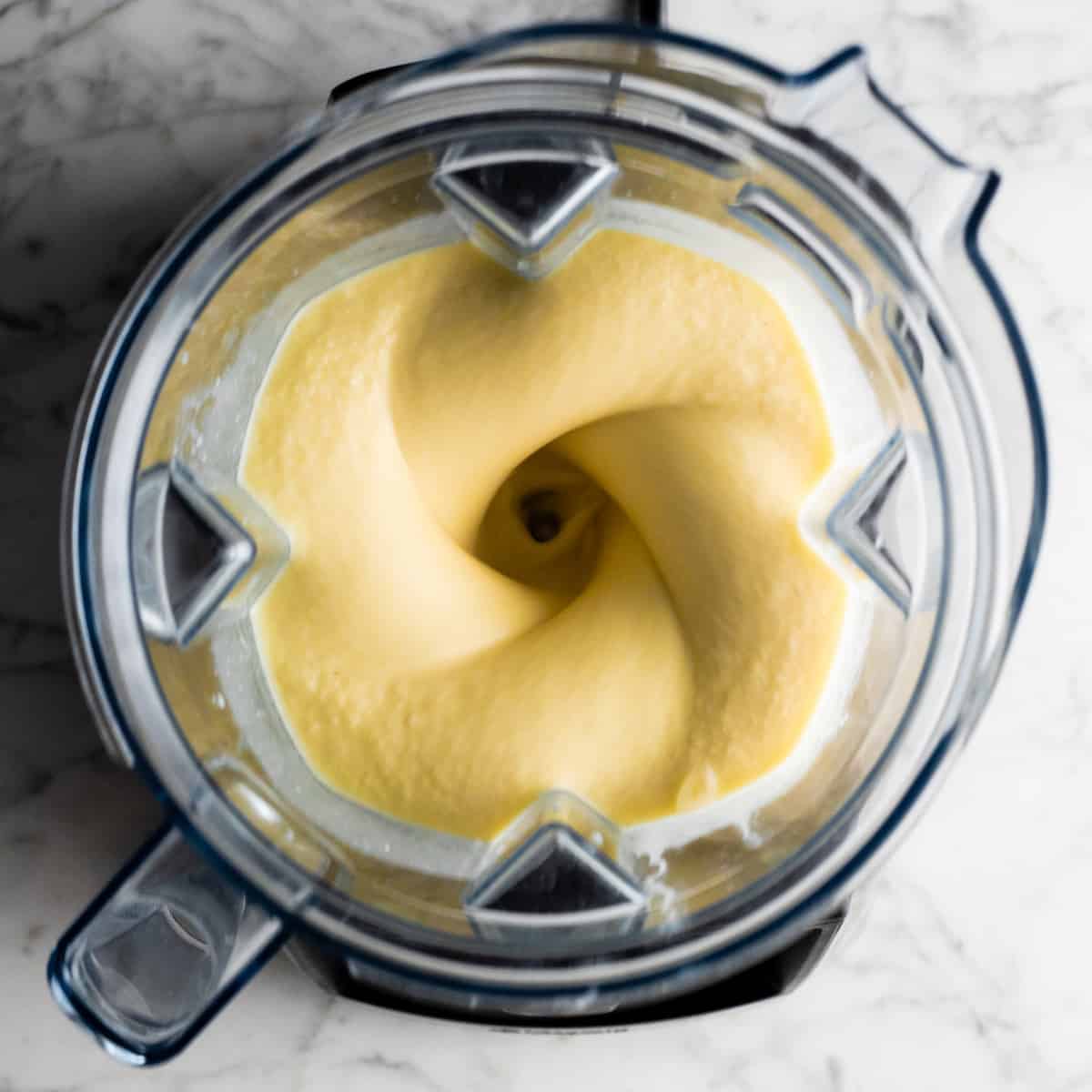 overhead view of pineapple smoothie blending in a vitamix blender