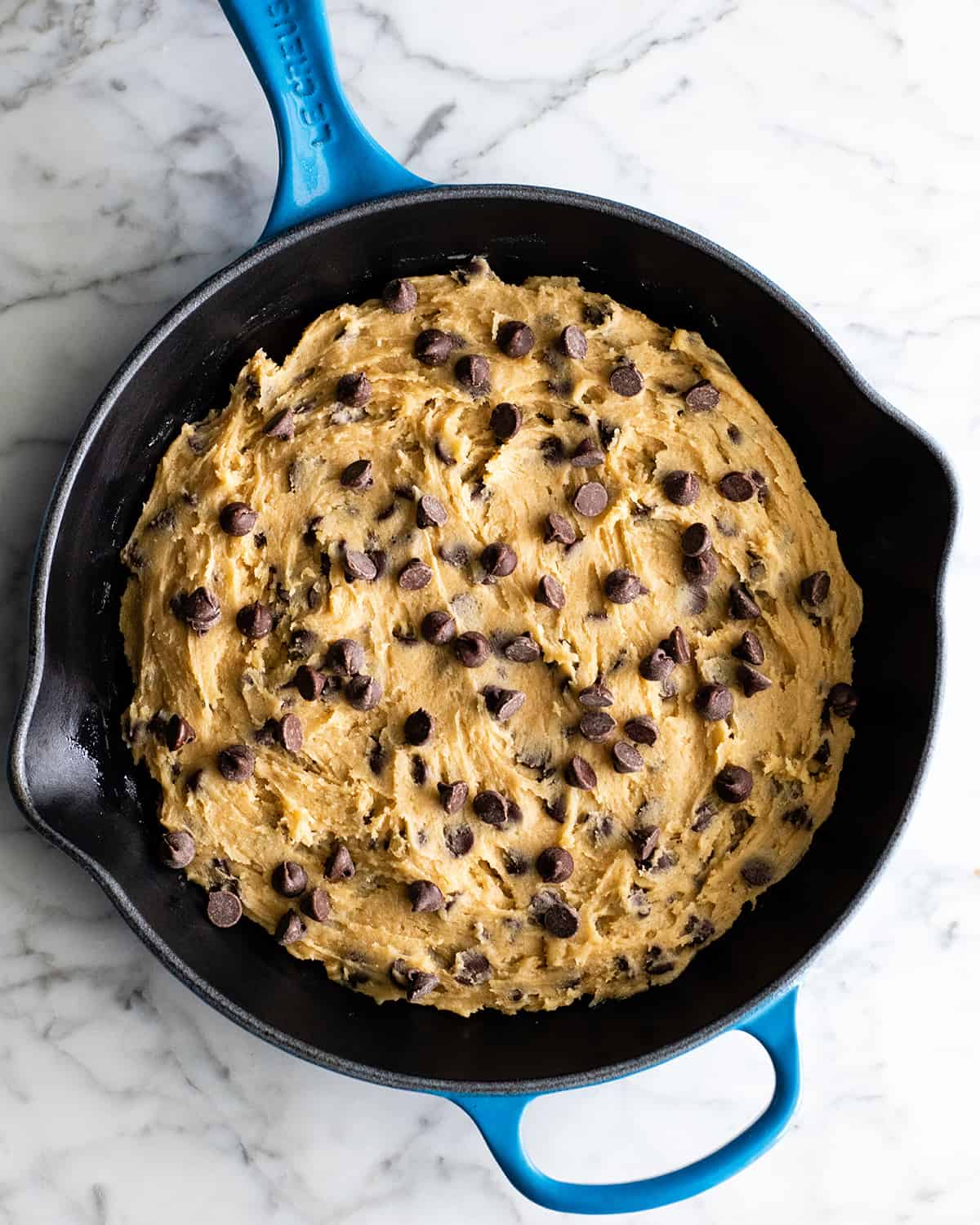 overhead view of skillet cookie batter in a skillet before baking