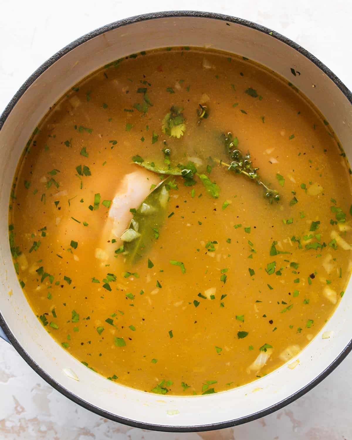 How to Make Chicken Noodle Soup adding chicken and herbs 