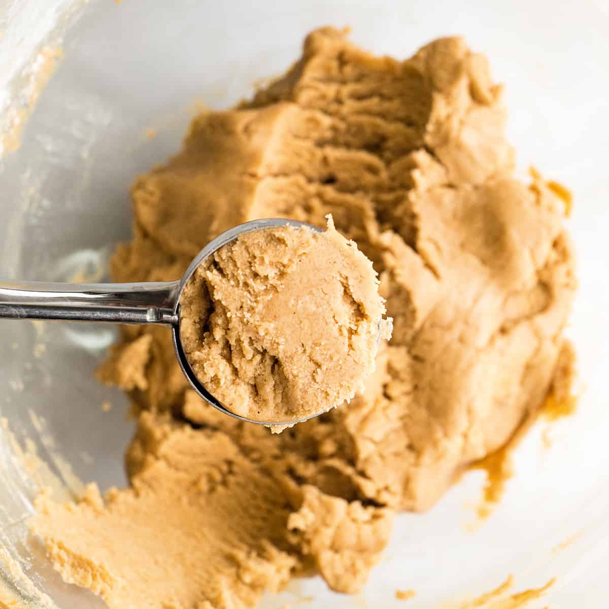 a cookie scoop measuring peanut butter cookie dough
