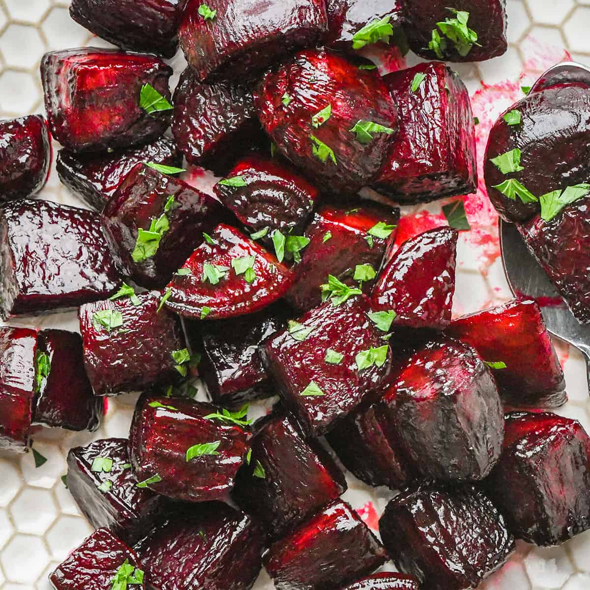 Made with 5 ingredients including fresh beets, this easy Balsamic Roasted Beets recipe is a great side dish or addition to your favorite salad! They are gluten-free, dairy-free, Paleo and vegan-friendly! #beets #roastedbeets #sidedish #roastedvegetables oven roasted beets on a plate garnished with beet greens