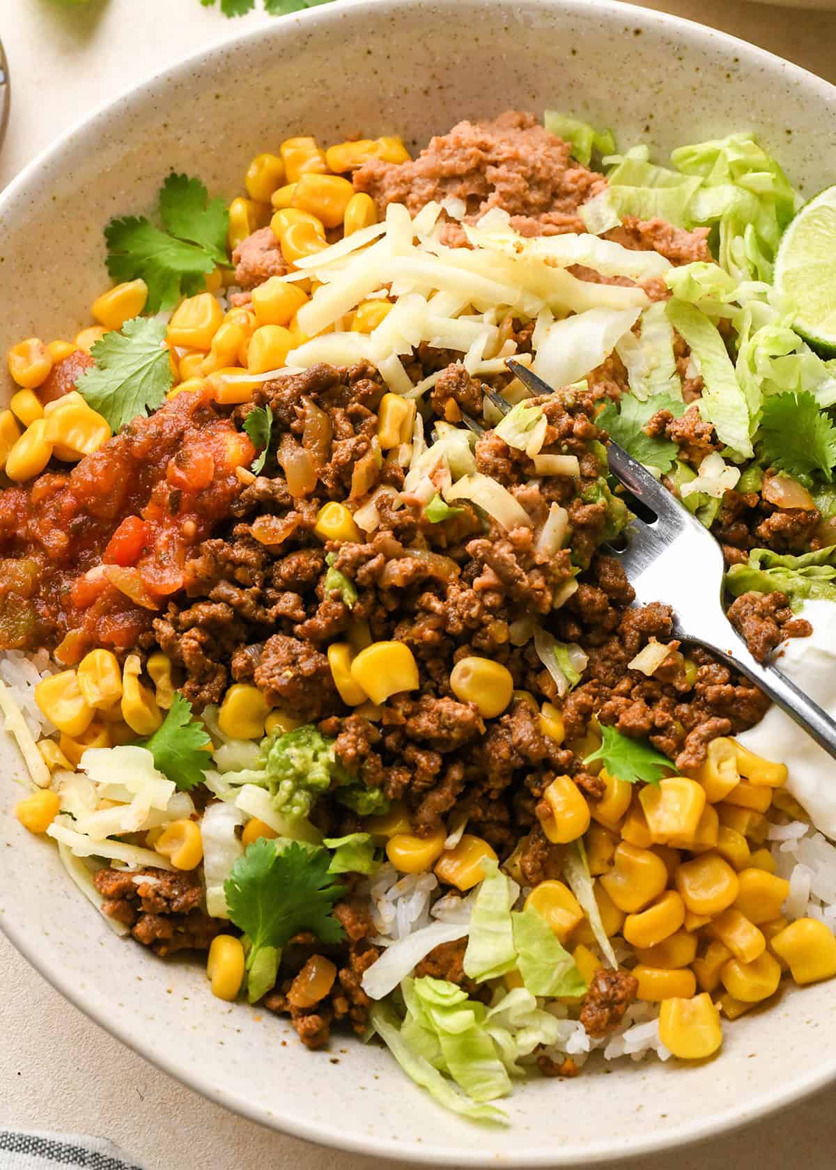 a taco bowl with a fork taking a bite