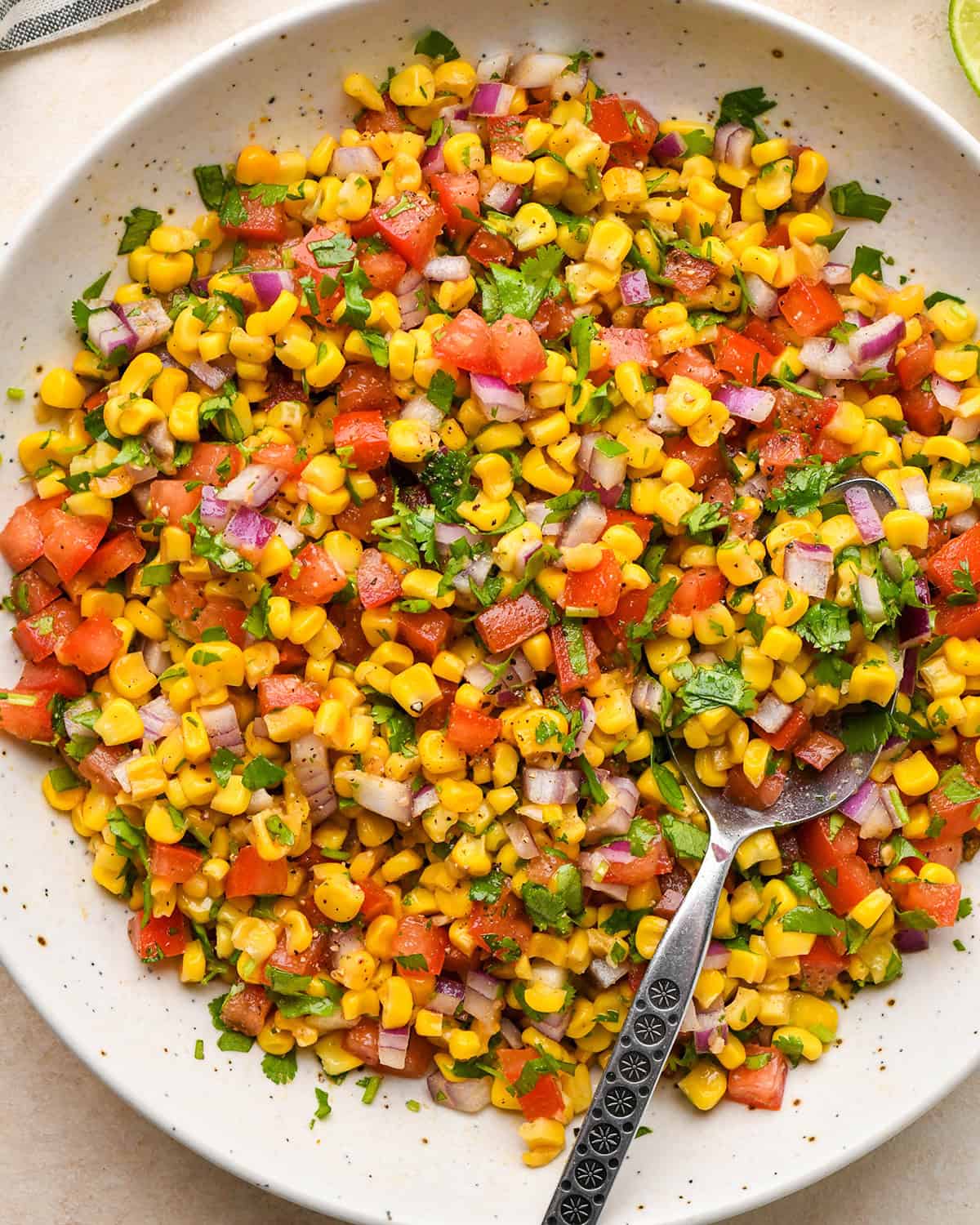corn salsa in a bowl with a spoon 