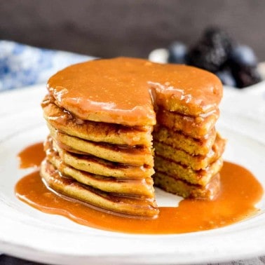 A stack of six Zucchini Banana Pancakes with a bite taken out of it